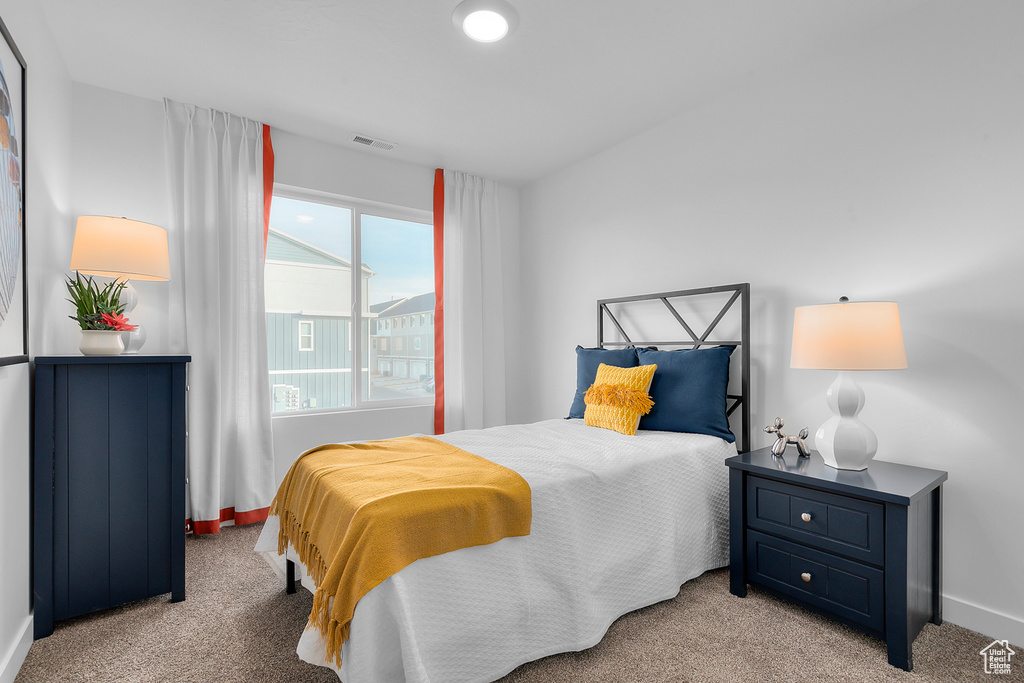 Bedroom with light carpet, baseboards, and visible vents