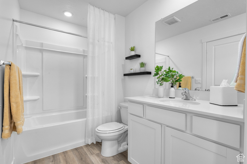 Bathroom with visible vents, toilet, vanity, and wood finished floors
