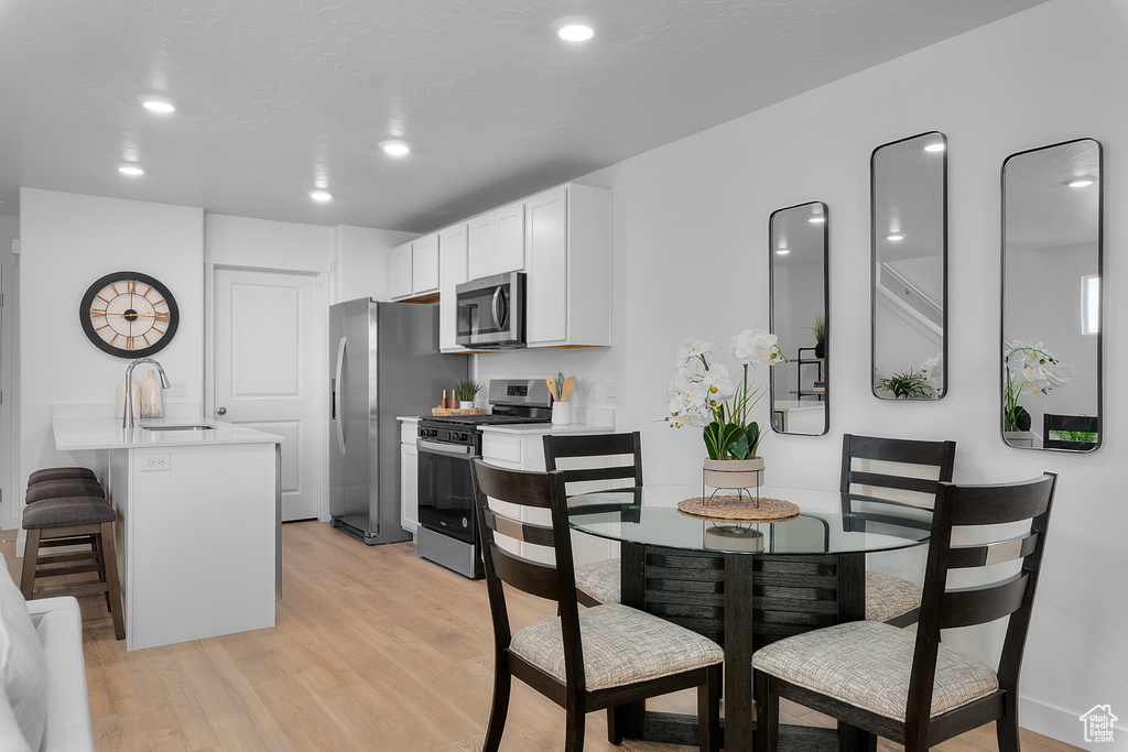 Dining area with light wood-type flooring and recessed lighting
