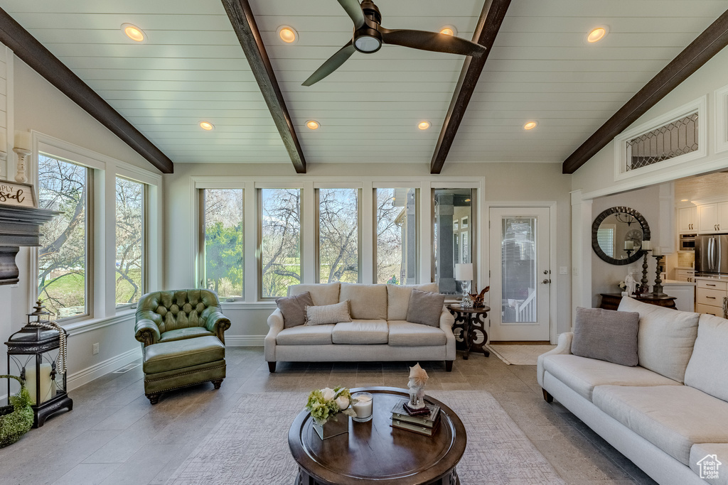 Living area with vaulted ceiling with beams, recessed lighting, ceiling fan, and baseboards