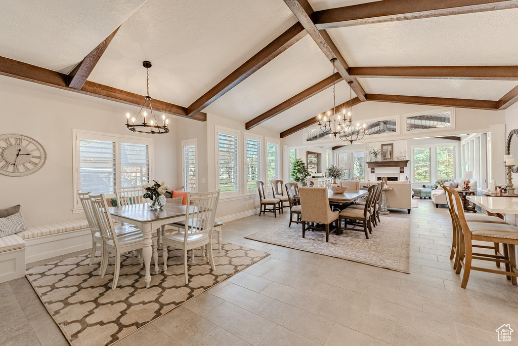 Dining room with beam ceiling, a chandelier, and plenty of natural light