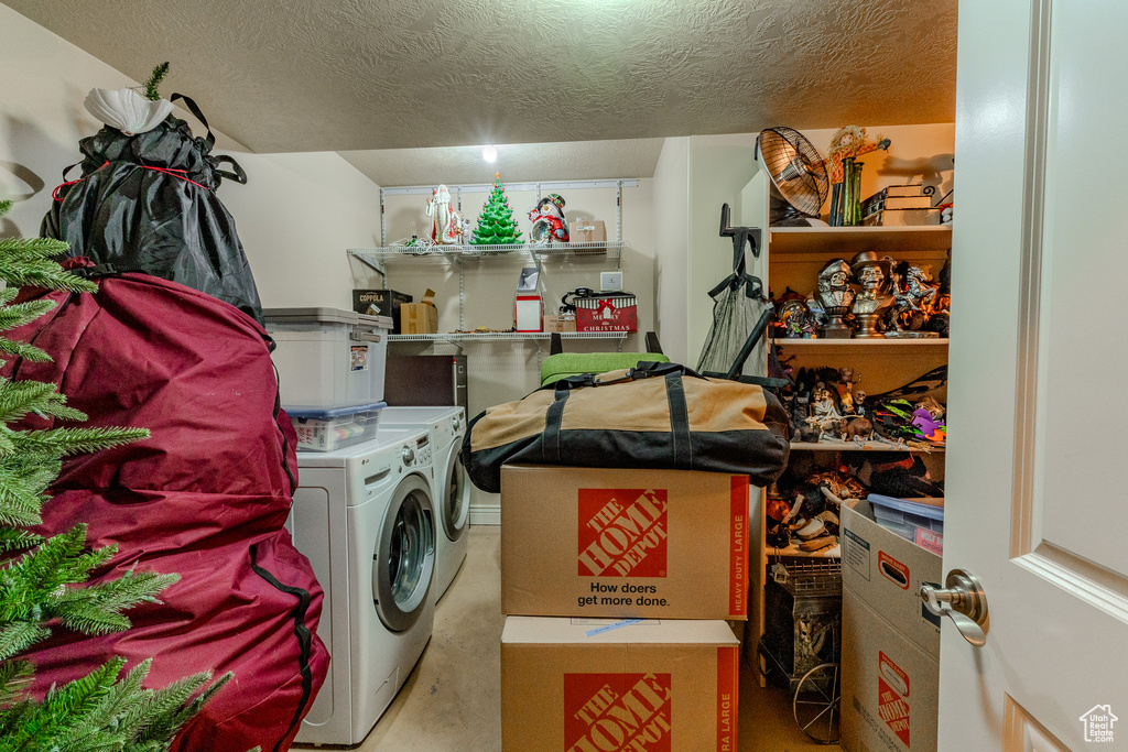 Laundry room with washer and dryer, laundry area, and a textured ceiling