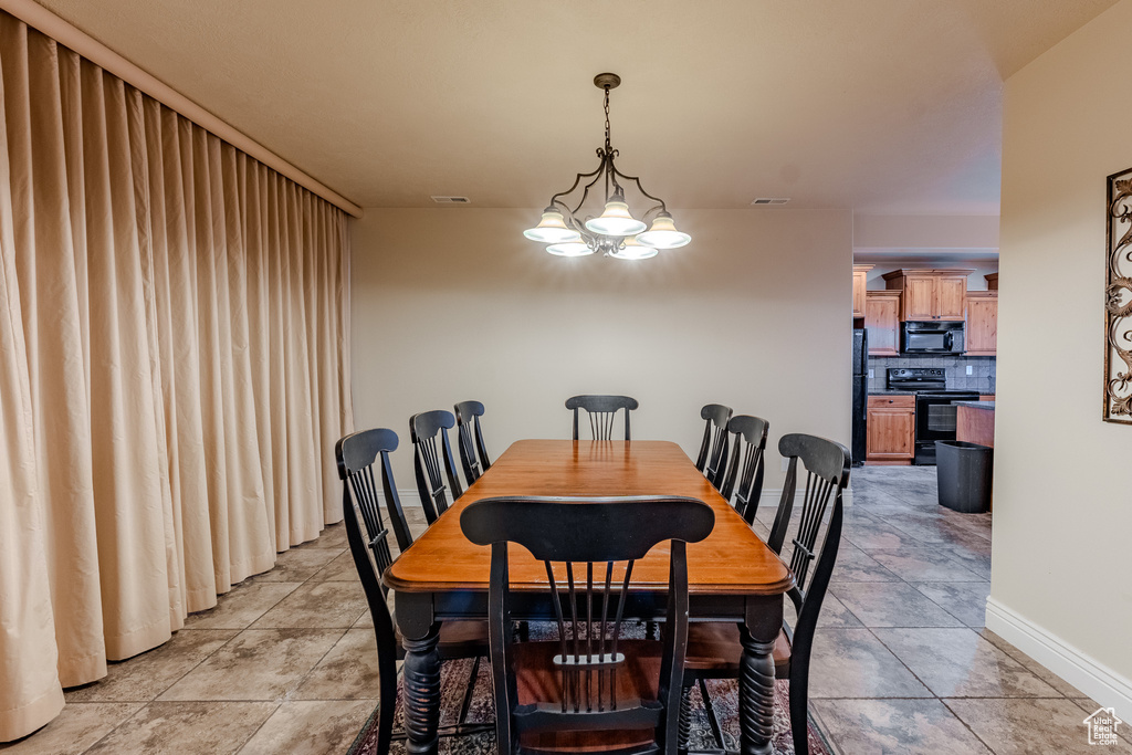 Dining area with light tile patterned floors, baseboards, and visible vents