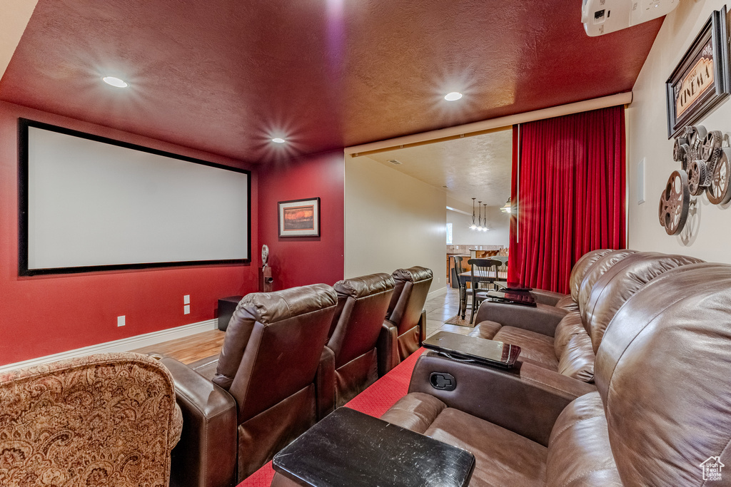 Cinema room featuring wood finished floors, a textured ceiling, baseboards, and recessed lighting