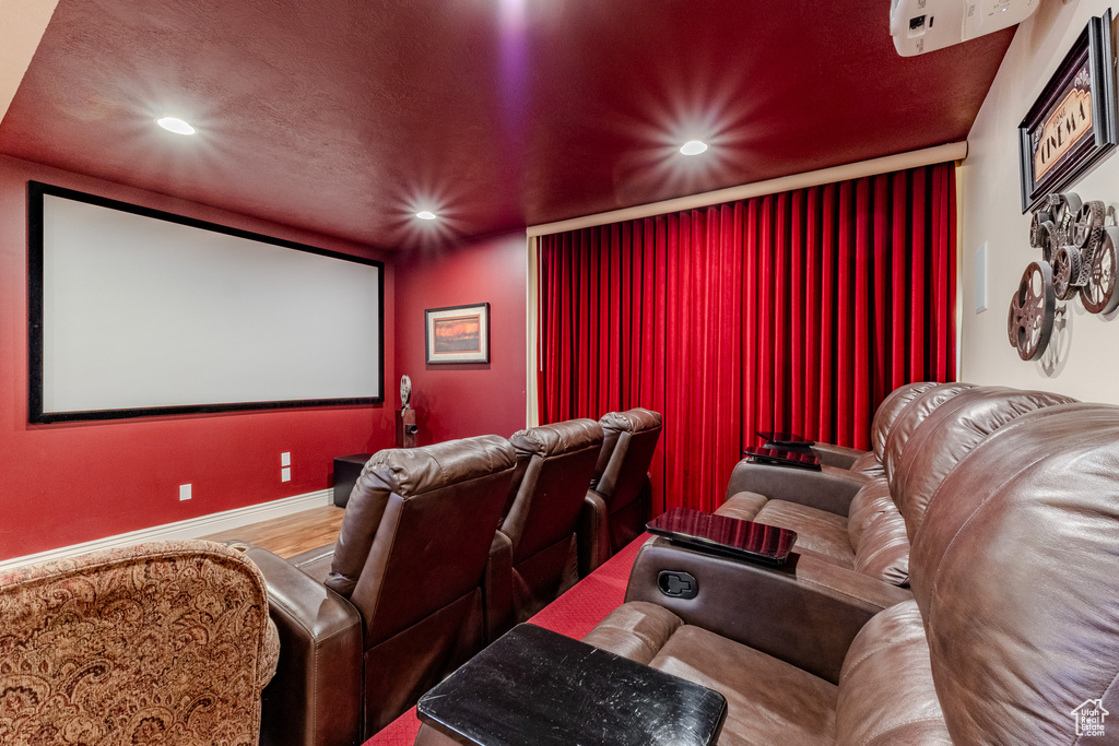 Home theater with recessed lighting, baseboards, and wood finished floors