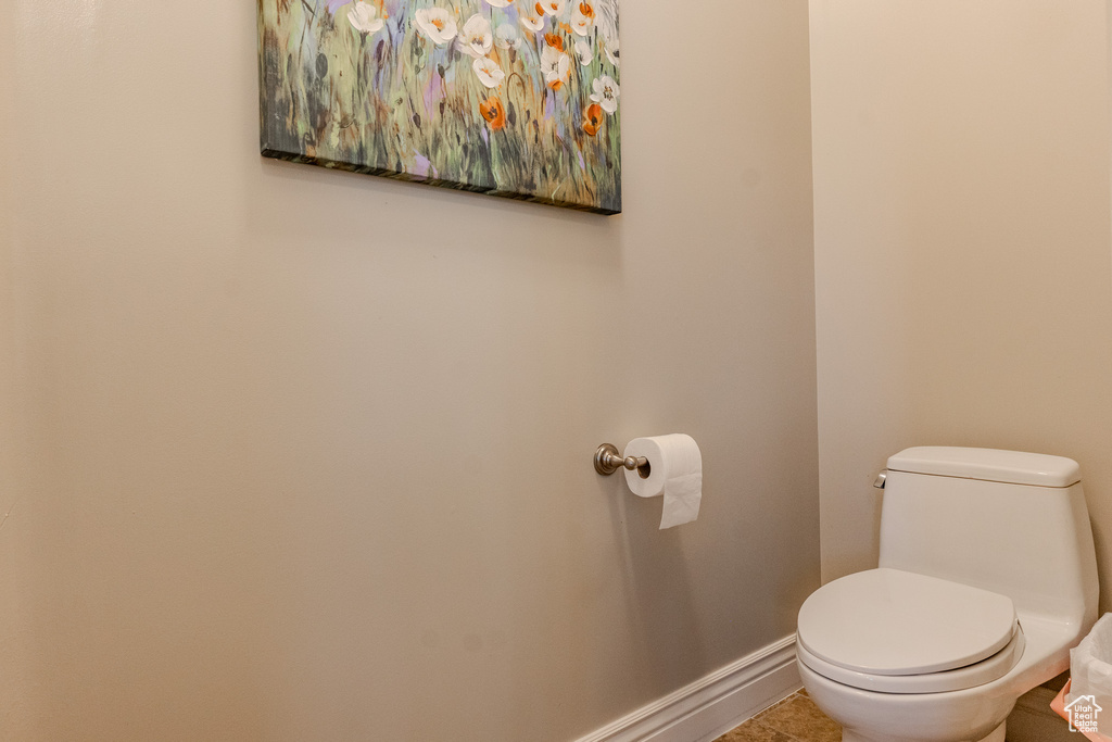 Bathroom featuring baseboards, toilet, and tile patterned flooring