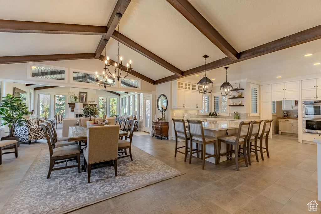 Dining area with beamed ceiling, high vaulted ceiling, and a notable chandelier