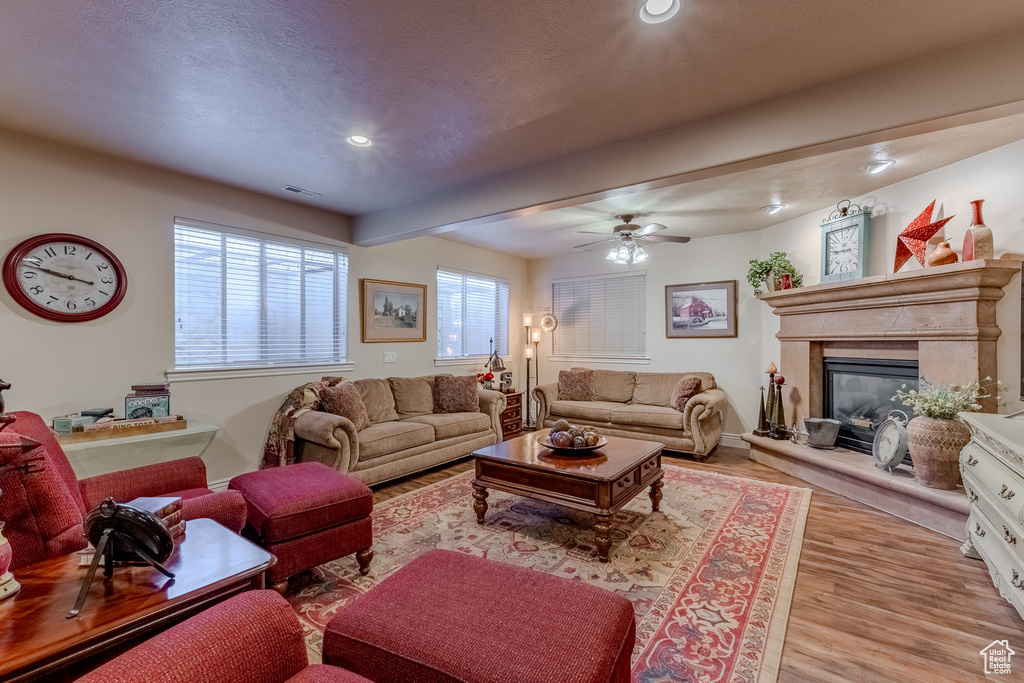Living area featuring a ceiling fan, wood finished floors, a premium fireplace, visible vents, and recessed lighting