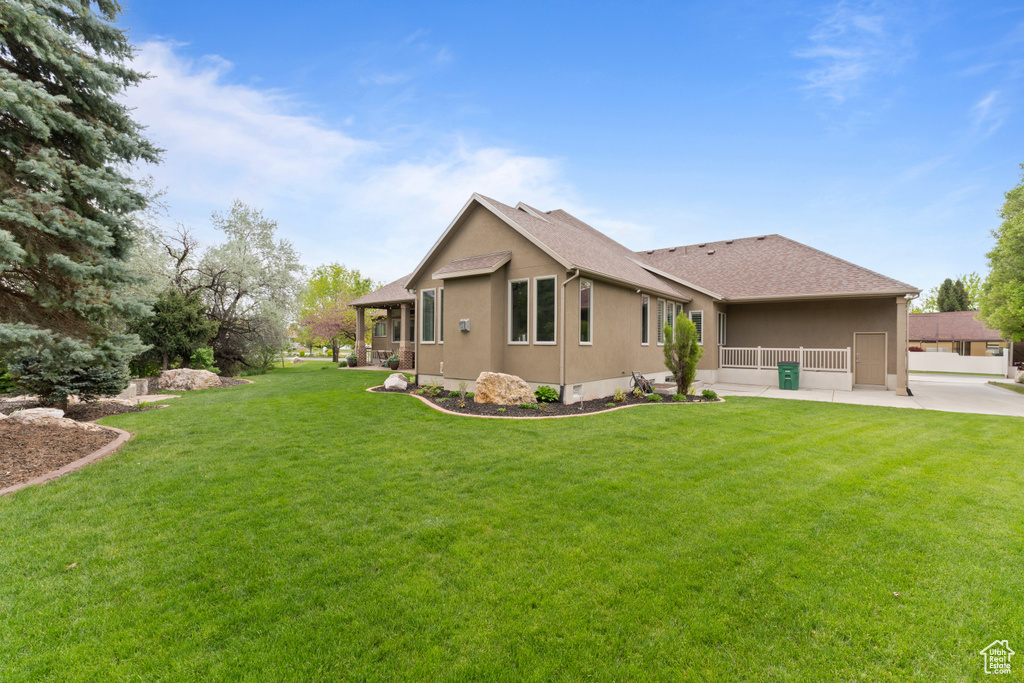 Back of property with a yard and roof with shingles