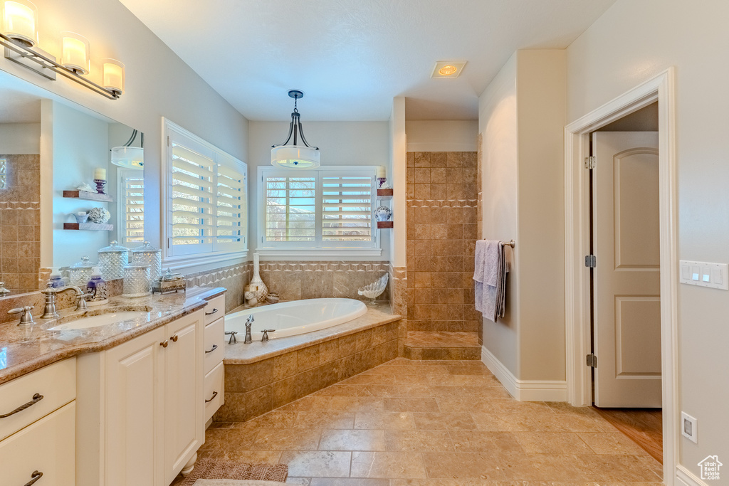 Bathroom with vanity, a walk in shower, and a bath