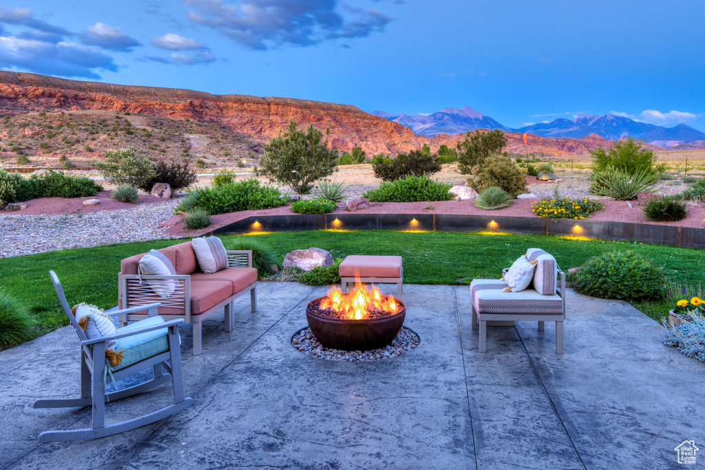 View of patio with an outdoor fire pit and a mountain view