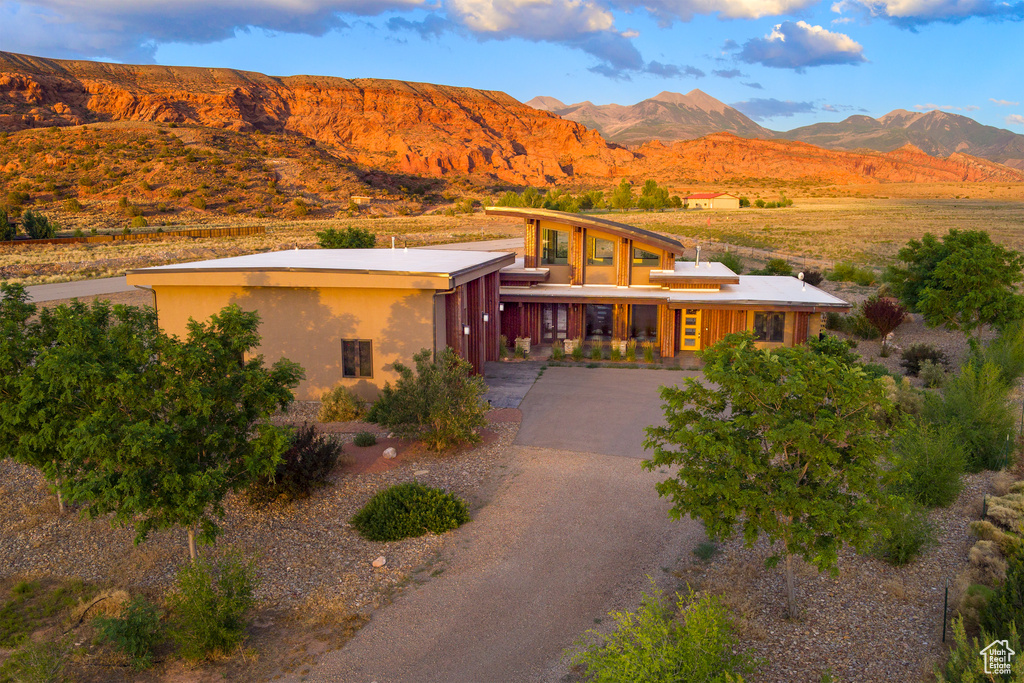 View of front facade with a mountain view, driveway, stucco siding, and an attached garage