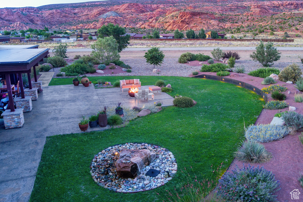 View of grassy yard with a patio area and a mountain view