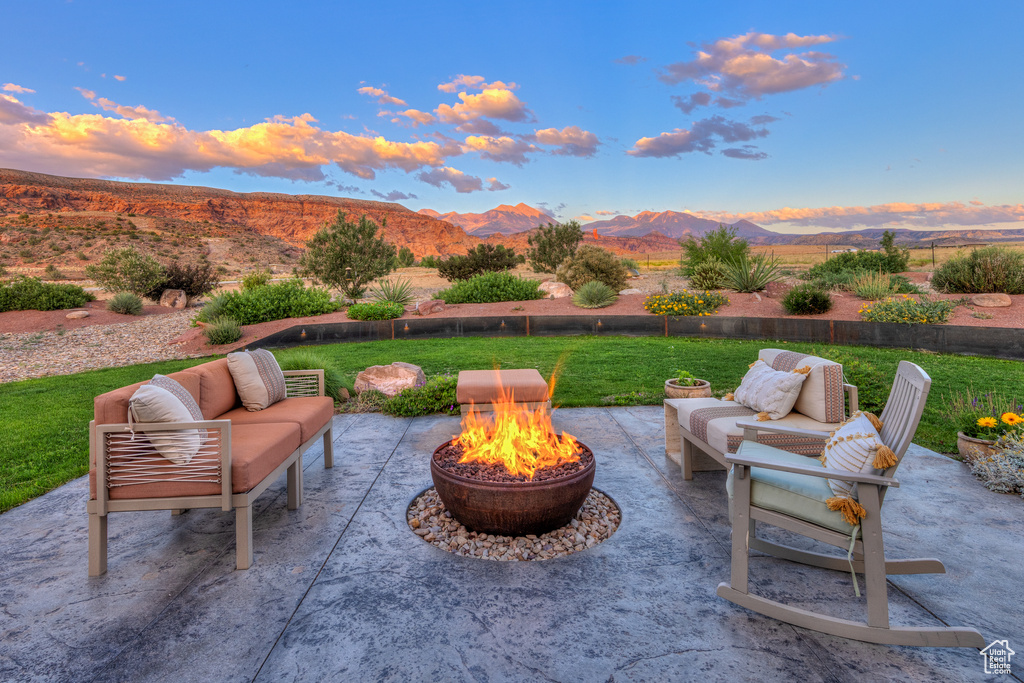 Patio terrace at dusk with a patio, a mountain view, and an outdoor living space with a fire pit