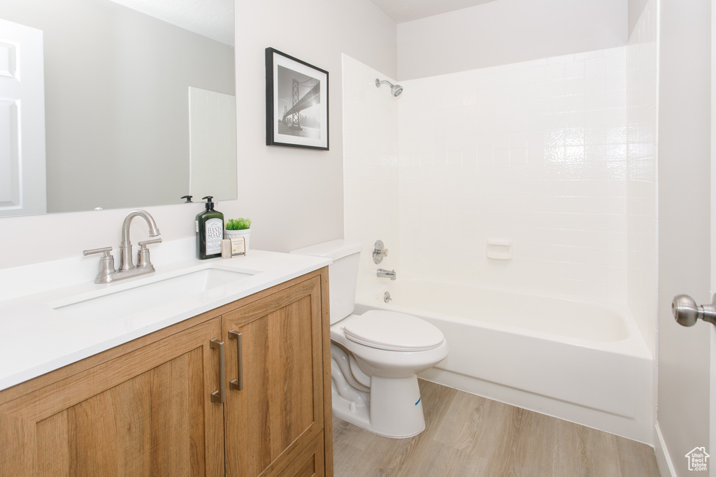 Full bath featuring  shower combination, wood finished floors, toilet, and vanity