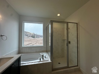 Bathroom featuring vanity, a garden tub, tile patterned flooring, and a shower stall