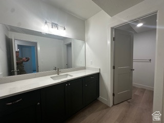 Bathroom with baseboards, wood finished floors, and vanity