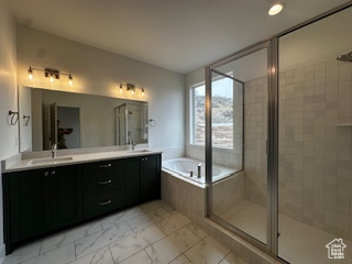 Full bath with a shower stall, marble finish floor, double vanity, a sink, and a garden tub