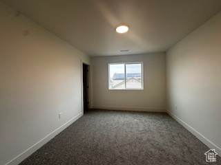 Carpeted empty room with baseboards
