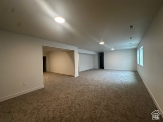 Basement featuring baseboards and carpet flooring