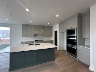 Kitchen with a sink, a large island, stainless steel appliances, and gray cabinets