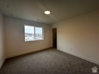 Carpeted empty room featuring baseboards