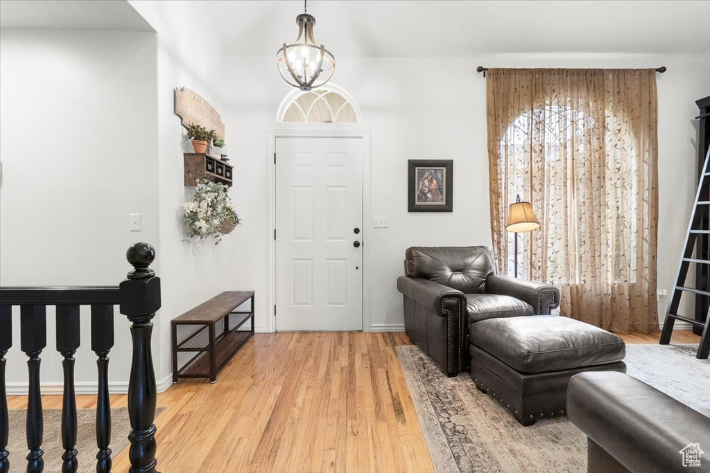 Foyer featuring an inviting chandelier, light wood-style flooring, and baseboards