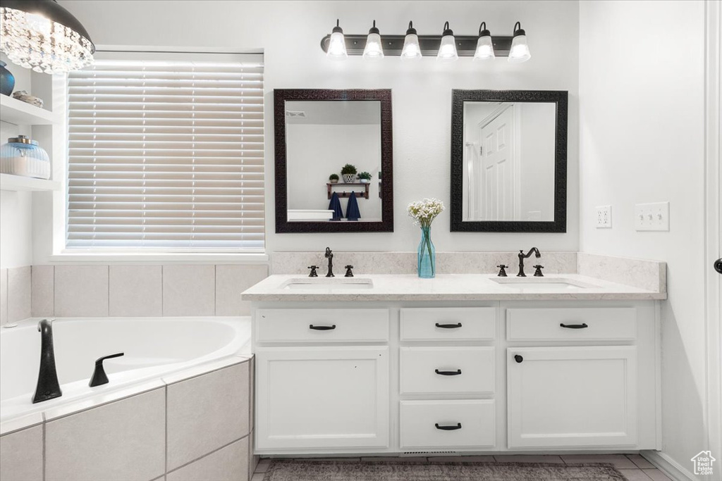 Full bath featuring a bath, double vanity, and a sink