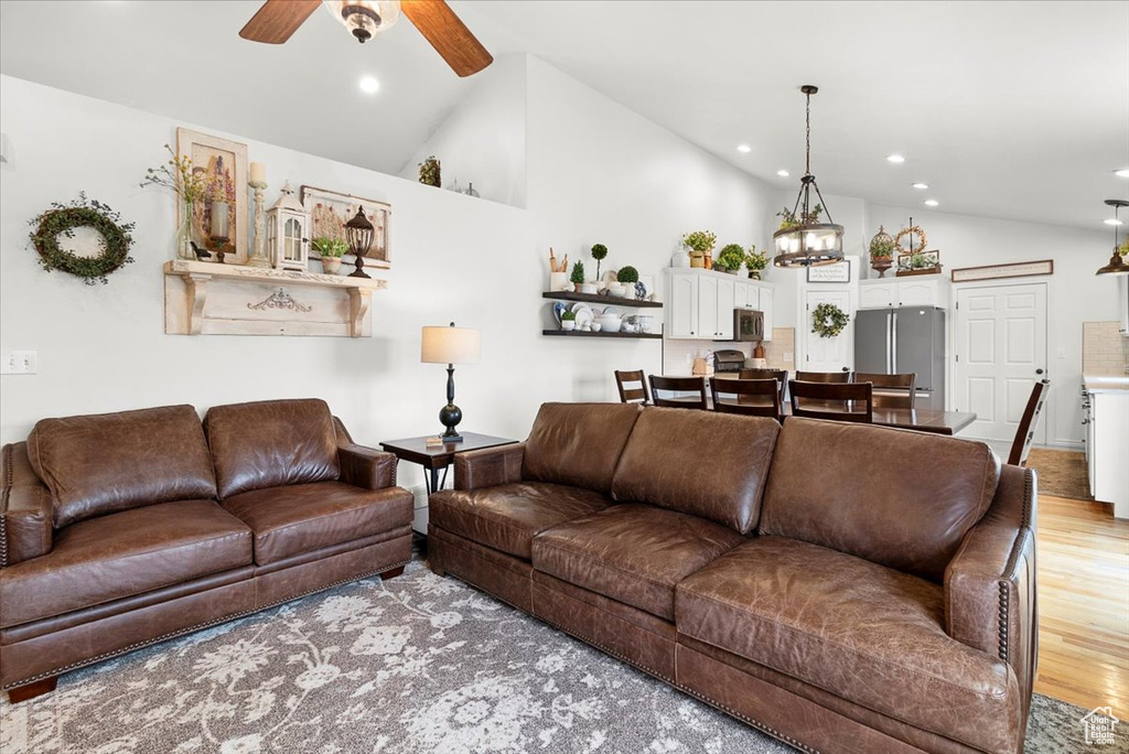 Living room featuring light wood-type flooring, recessed lighting, high vaulted ceiling, and ceiling fan
