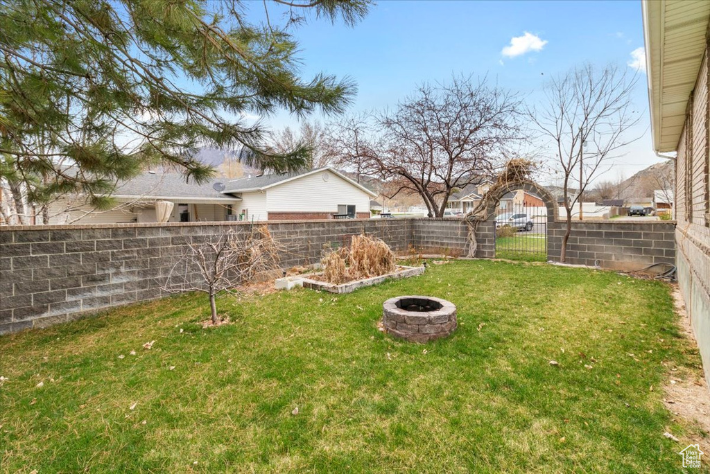 View of yard with an outdoor fire pit and a fenced backyard