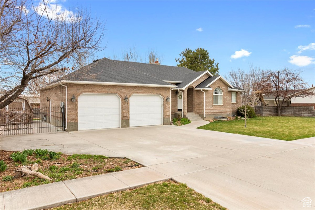 Ranch-style home with brick siding, driveway, fence, and an attached garage