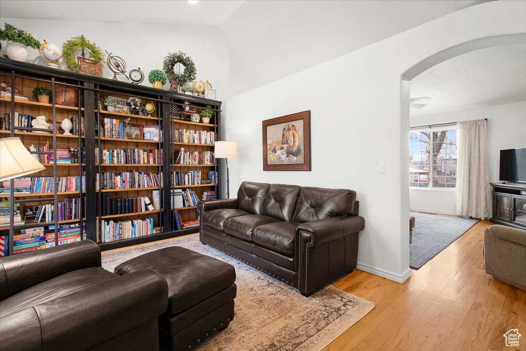 Interior space featuring arched walkways, baseboards, and wood finished floors