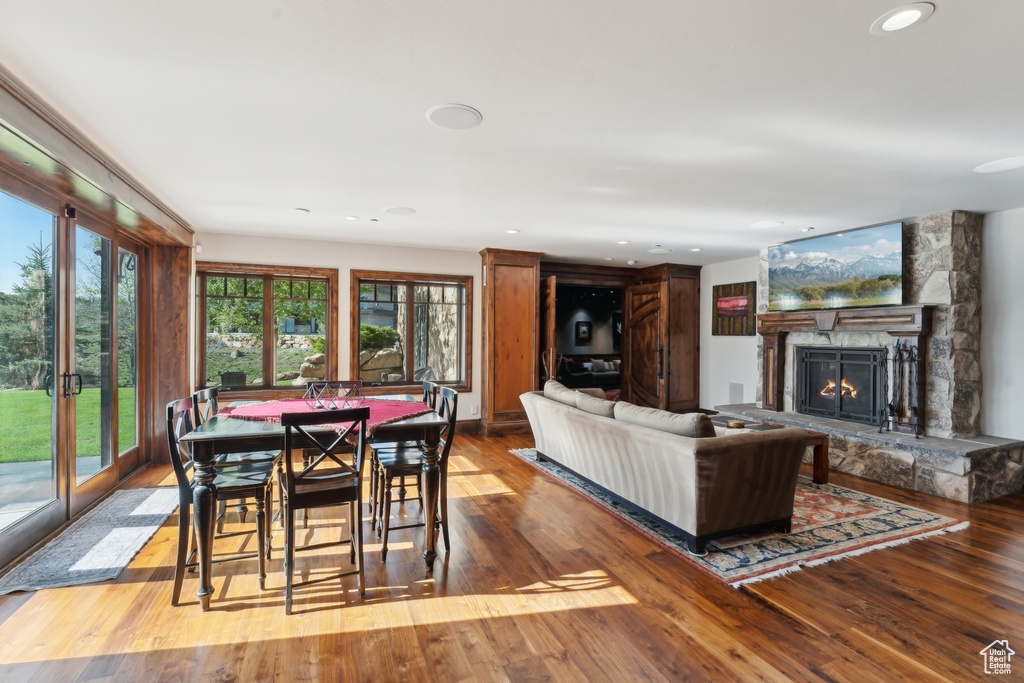 Living area with hardwood / wood-style floors, a stone fireplace, and recessed lighting