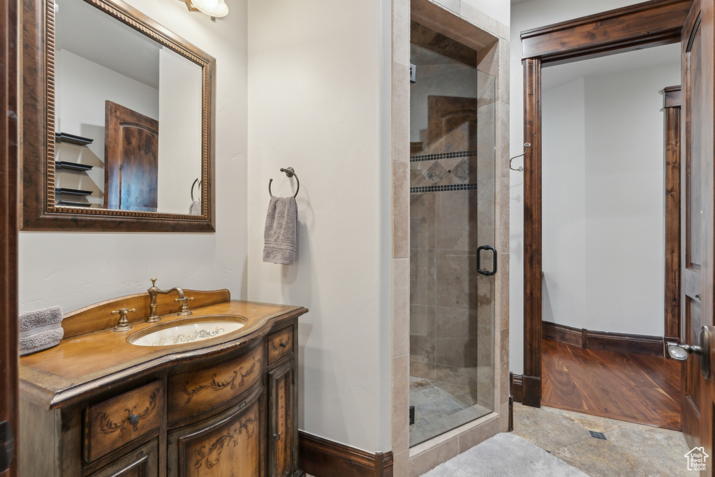 Full bathroom with vanity, baseboards, and a shower stall