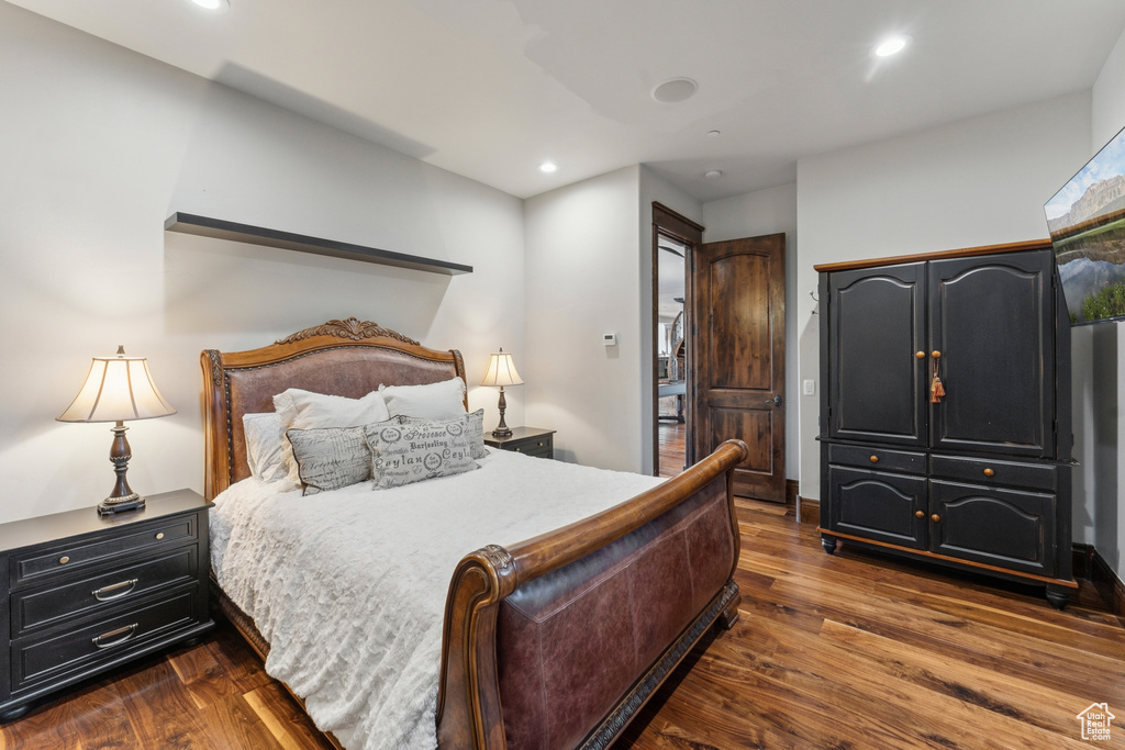 Bedroom with dark wood-style floors and recessed lighting