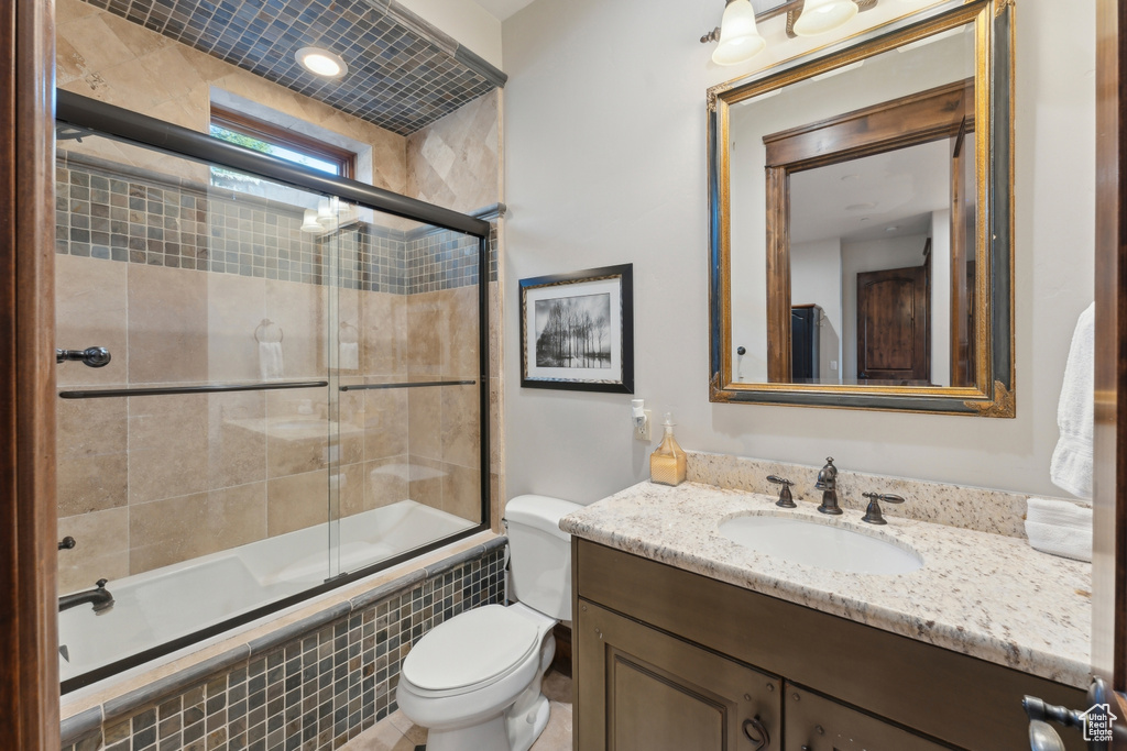 Full bathroom featuring tiled shower / bath, toilet, and vanity