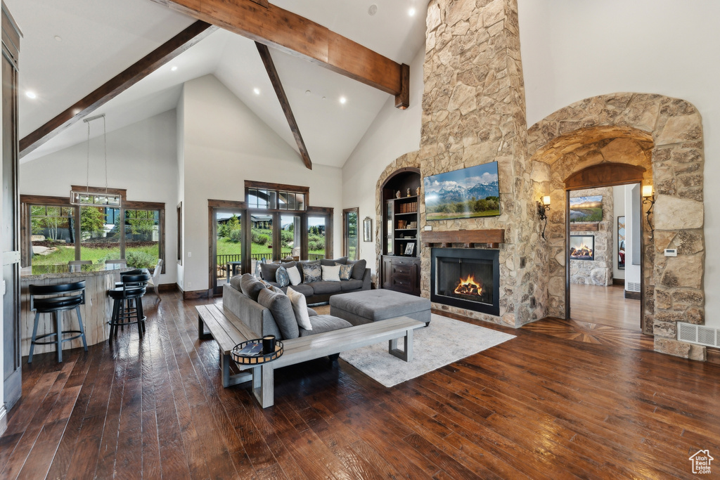 Living room with a fireplace, high vaulted ceiling, wood-type flooring, beam ceiling, and recessed lighting