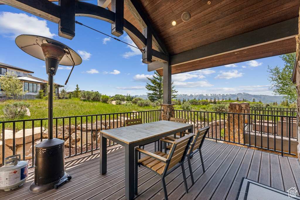 Wooden terrace featuring a mountain view and outdoor dining space