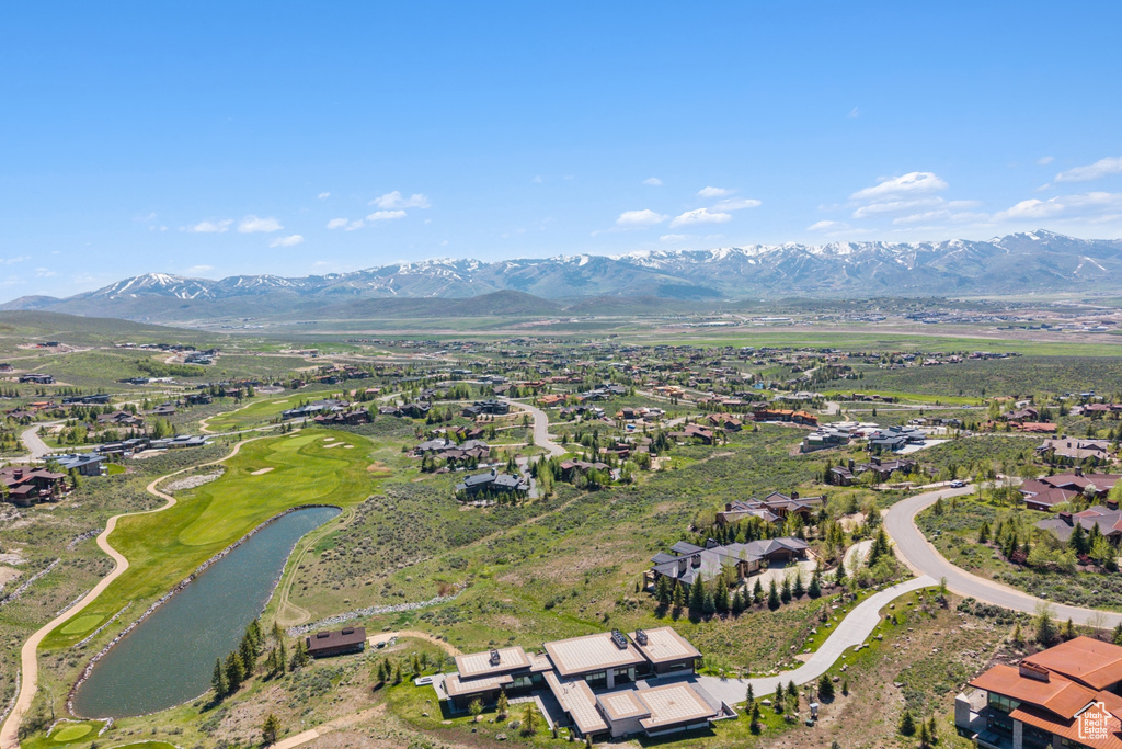 Aerial view of property's location featuring a water and mountain view, nearby suburban area, and a golf club