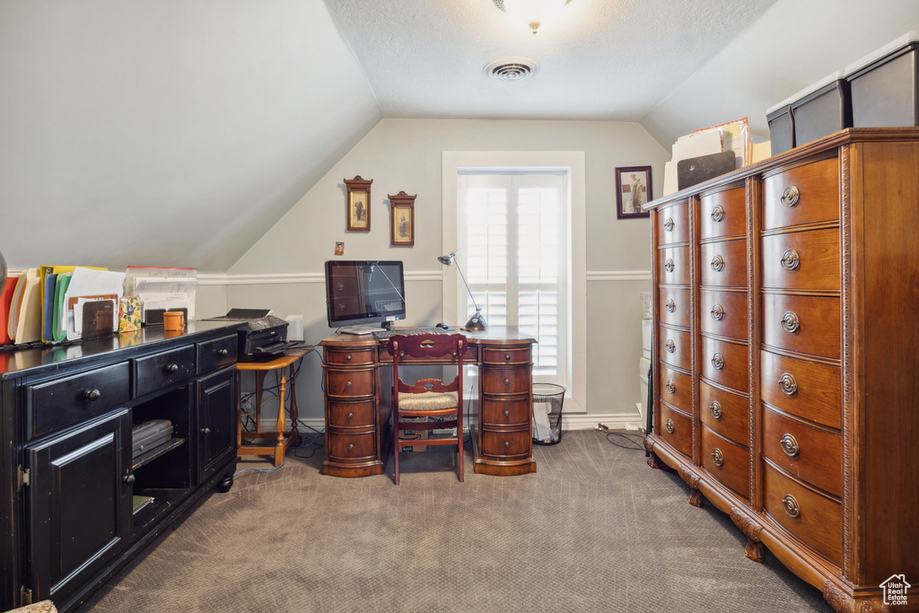 Carpeted home office with visible vents, lofted ceiling, and baseboards