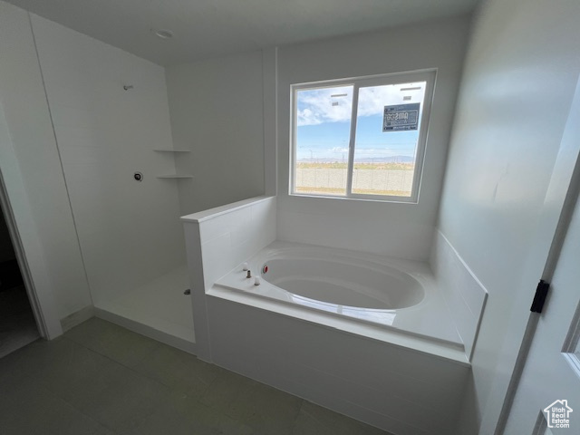 Bathroom with a garden tub, walk in shower, and tile patterned floors