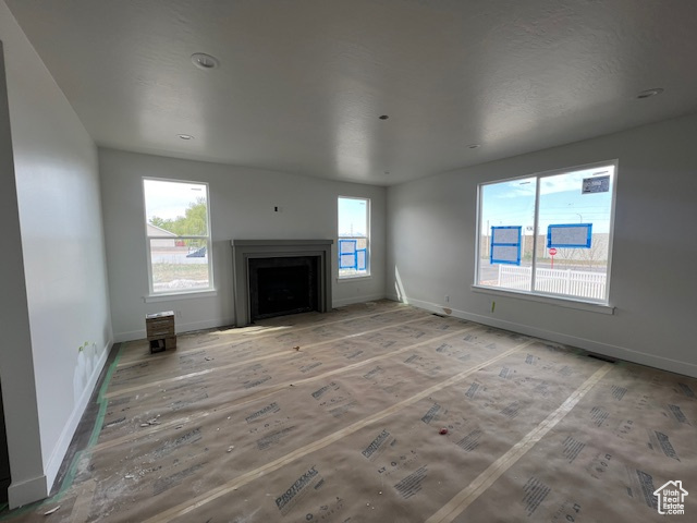 Unfurnished living room featuring baseboards and a fireplace