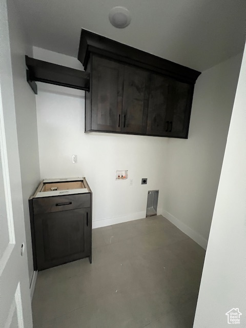 Washroom with baseboards, hookup for an electric dryer, cabinet space, and washer hookup