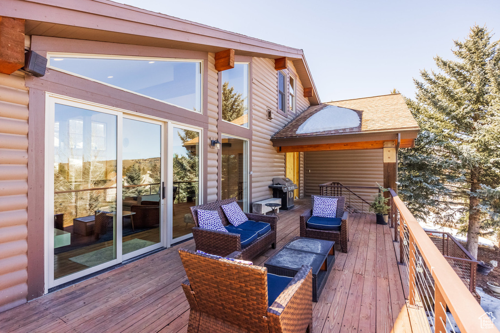 Deck with an outdoor living space and area for grilling