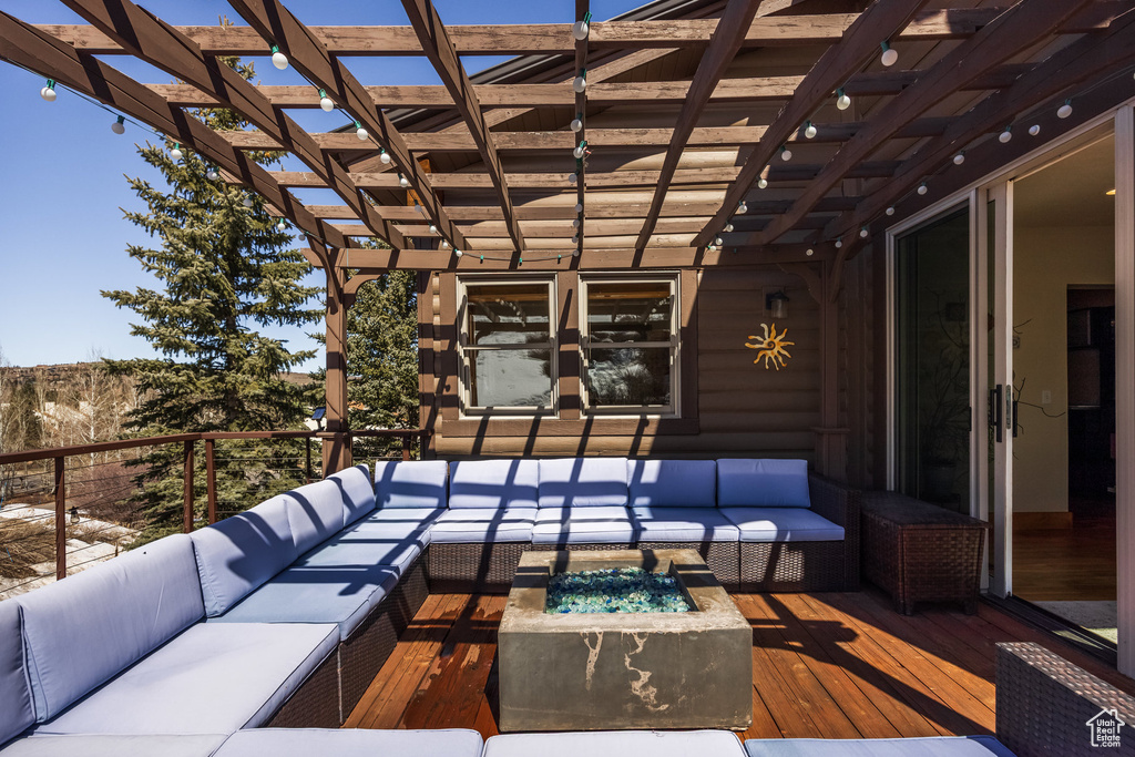 Deck with a pergola and an outdoor living space with a fire pit