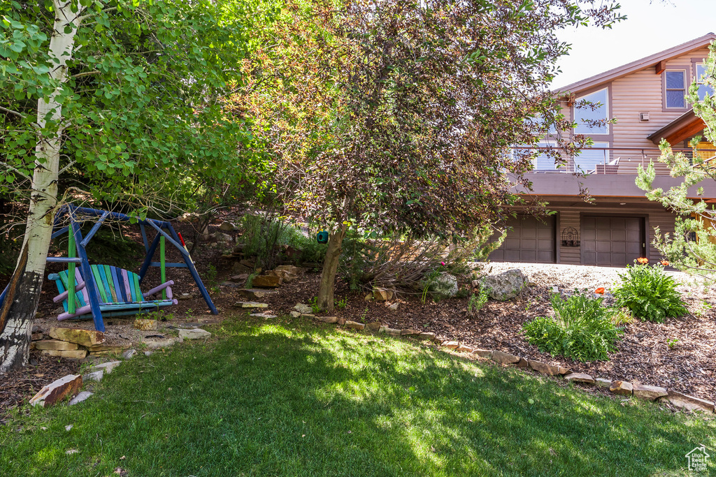 View of grassy yard with a garage