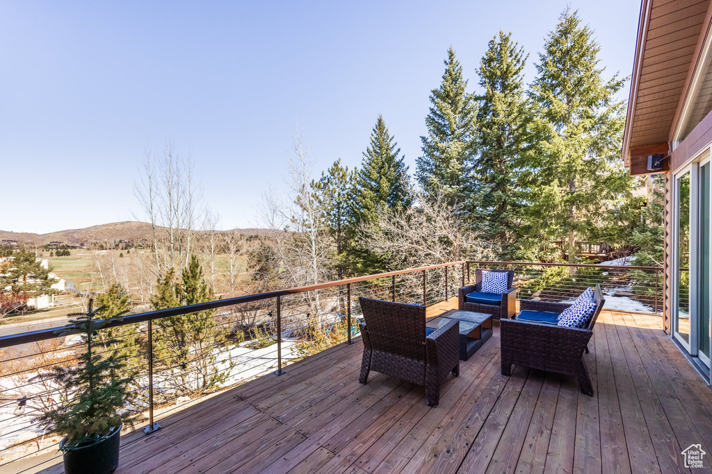 Wooden deck with a mountain view and outdoor lounge area