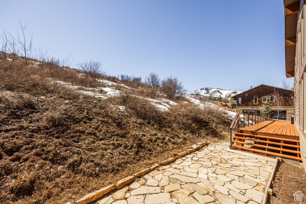 Snow covered patio featuring a deck with mountain view