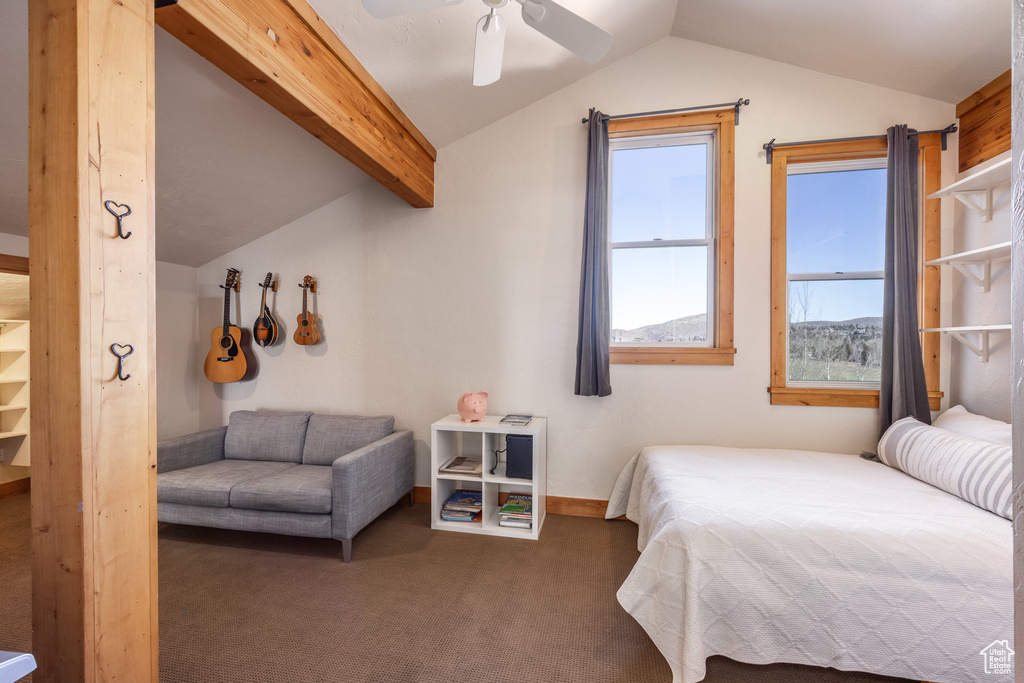 Carpeted bedroom featuring vaulted ceiling with beams, a ceiling fan, and baseboards