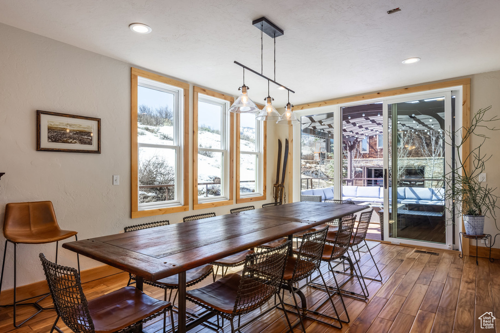 Dining area with plenty of natural light, recessed lighting, wood finished floors, and visible vents